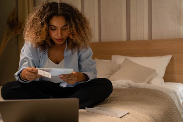 a person sitting on a bed reading a document